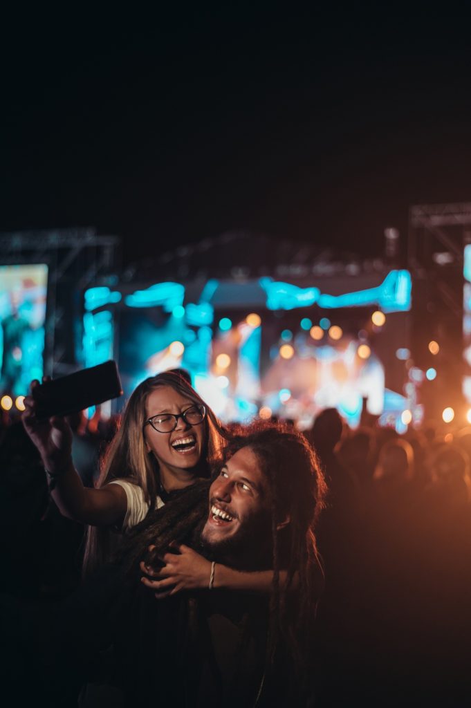 Couple taking selfie with a smartphone on a music festival