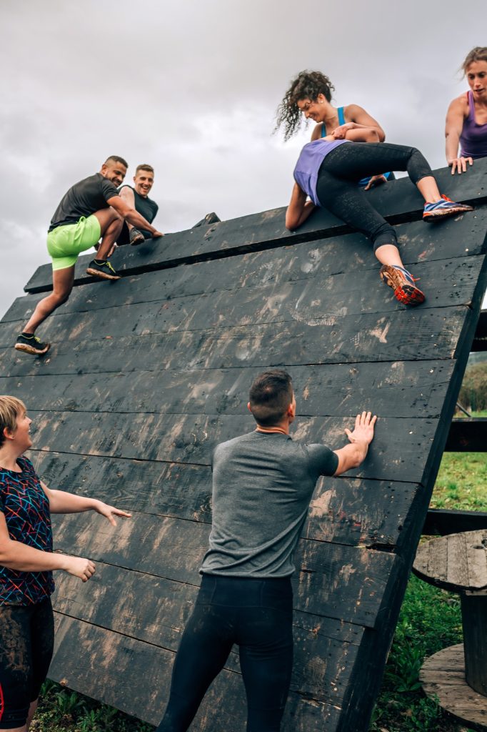 Participants in obstacle course climbing pyramid obstacle